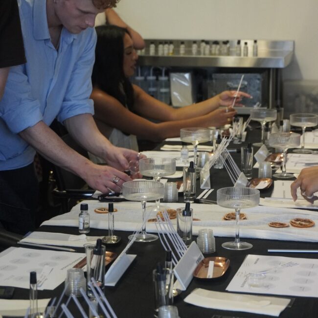 A participant blending fragrance with botanical essences during a Perfume Playground workshop.