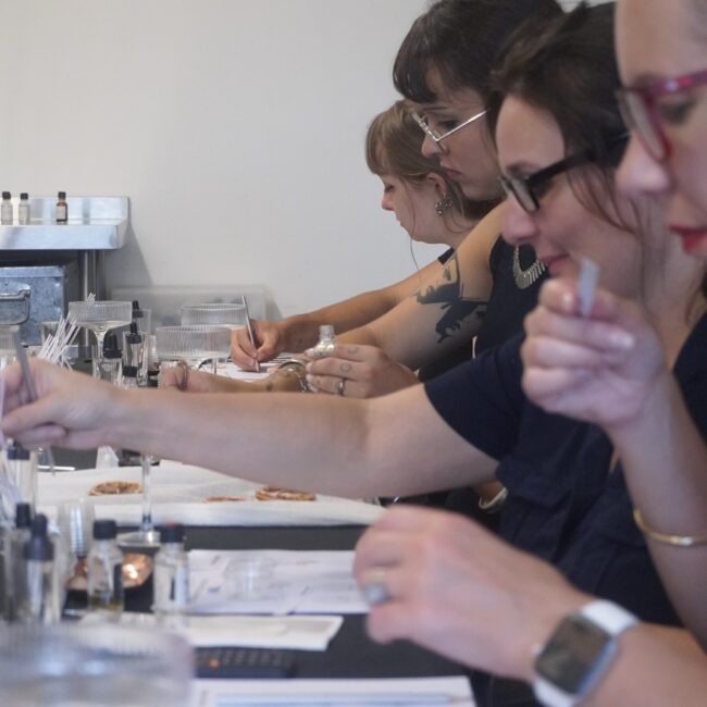 Participants smelling scent strips during a Perfume Playground fragrance workshop.